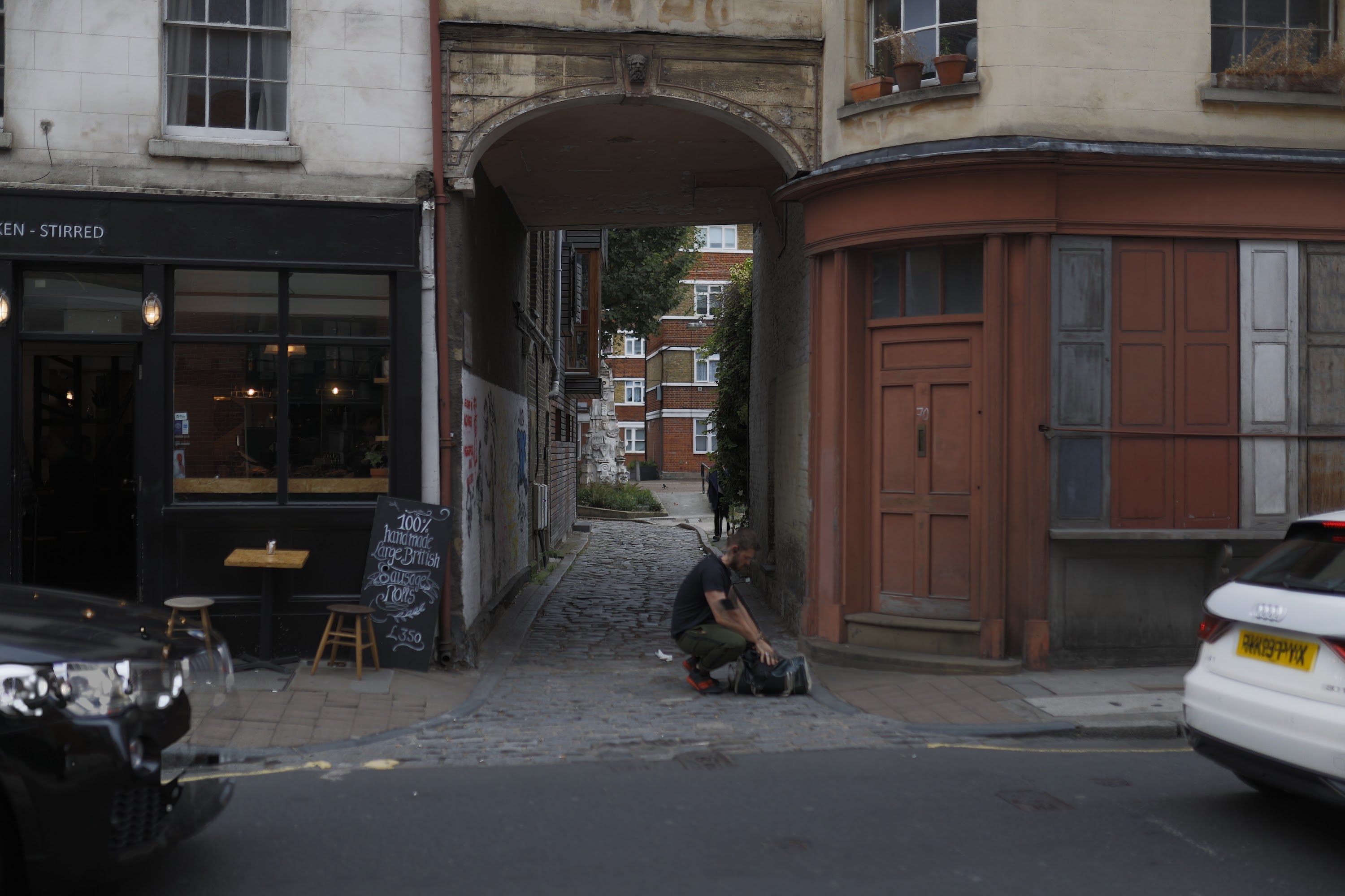 Man Packing Gear in Historic Alleyway