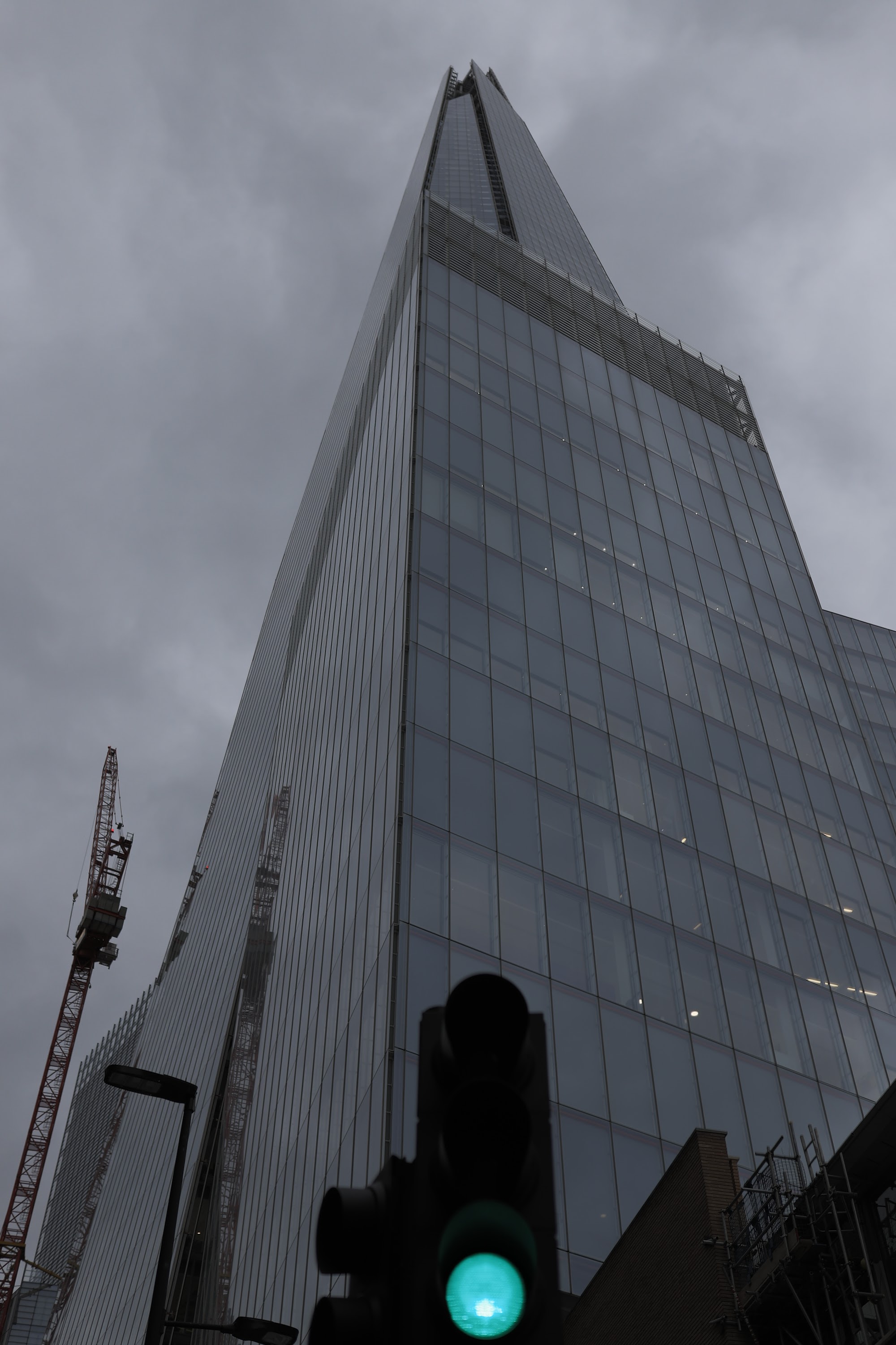 The Shard skyscraper under overcast sky with traffic light in foreground