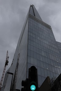 The Shard skyscraper under overcast sky with traffic light in foreground