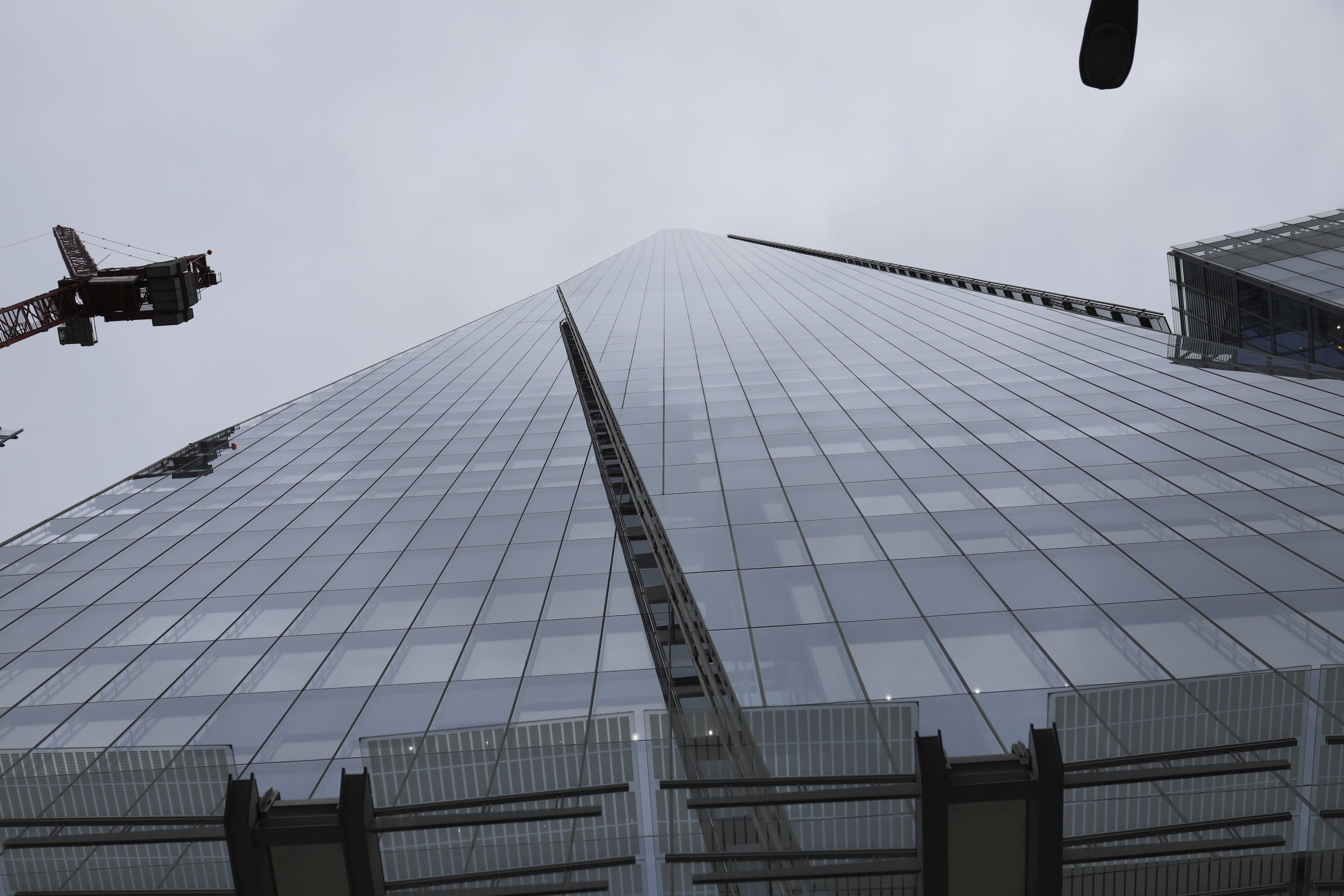 Low-angle view of The Shard skyscraper with construction crane