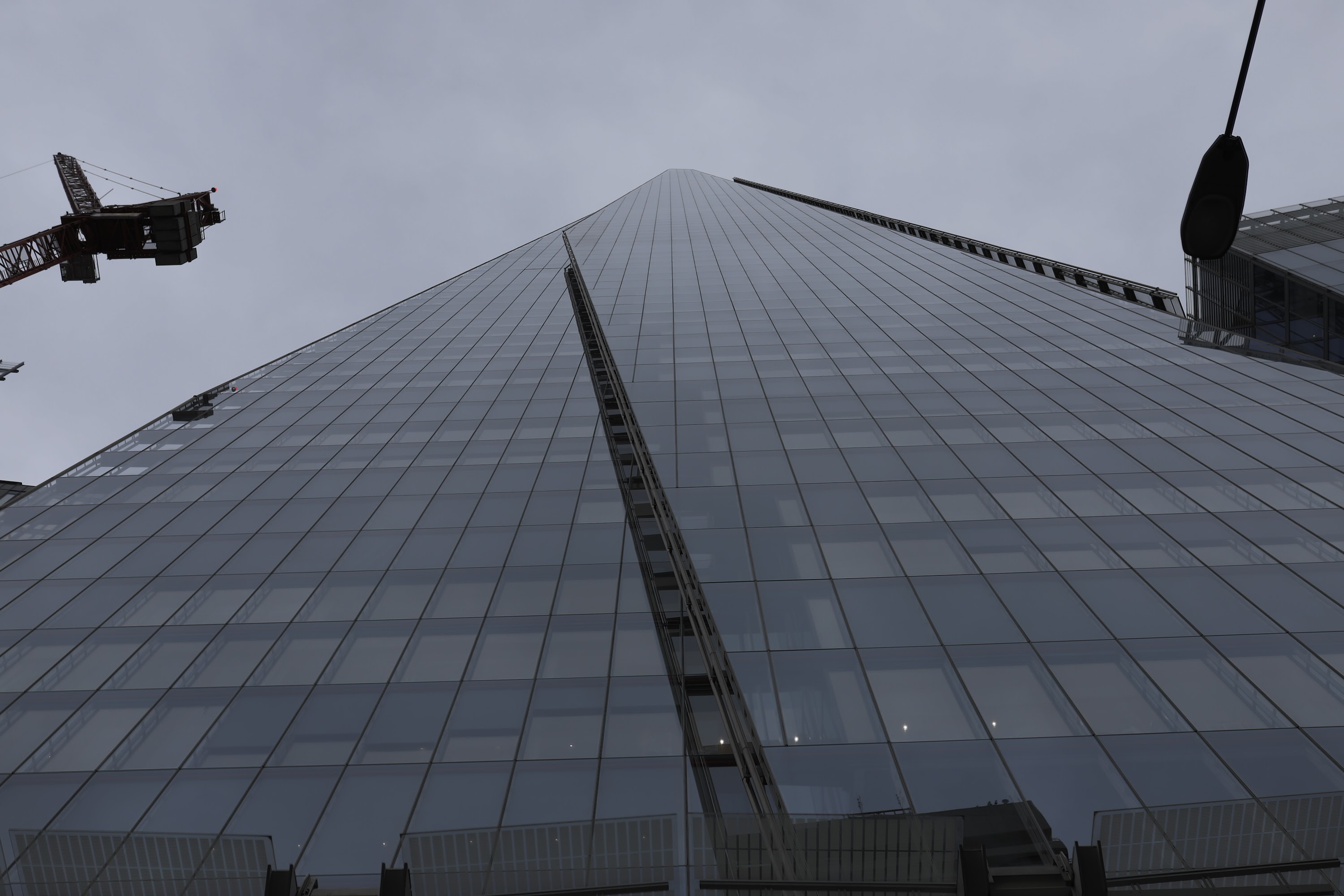 Low-angle view of The Shard skyscraper with construction crane