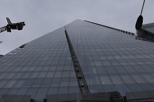 Low-angle view of The Shard skyscraper with construction crane