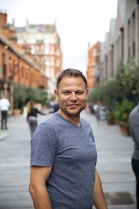 Smiling Man in Blue T-Shirt on Urban Street