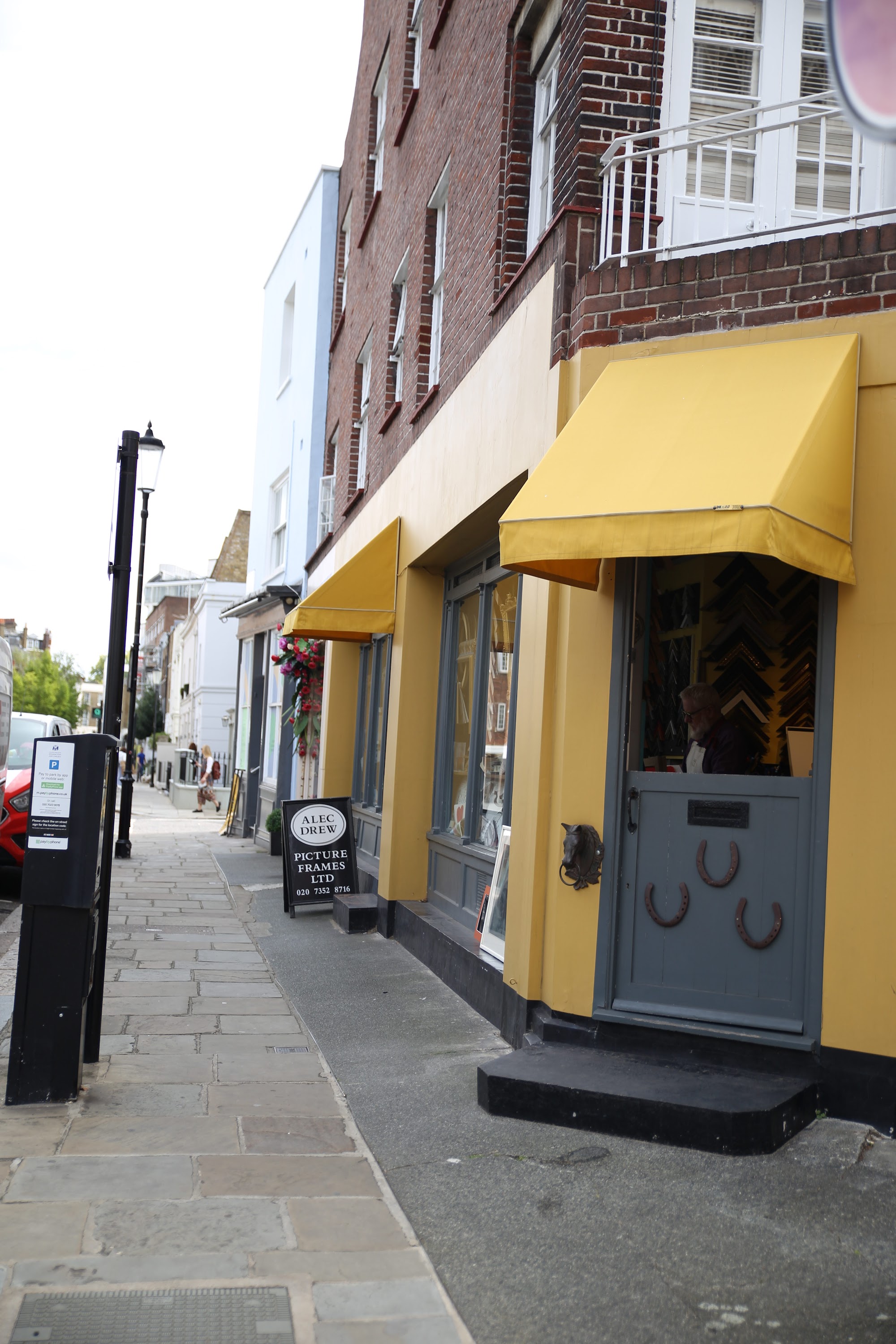 Yellow-Awned Shopfront with Horseshoe Decor