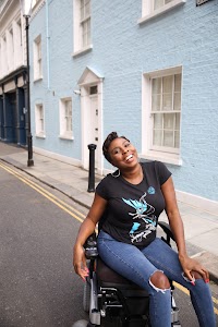 Woman in Power Wheelchair on Colorful Residential Street