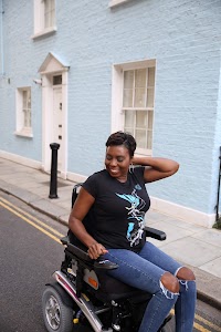 Woman in Power Wheelchair on Colorful Residential Street