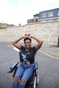 Woman in Power Wheelchair on Colorful Residential Street