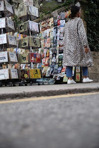 Woman Browsing Vintage Posters at Outdoor Street Stall