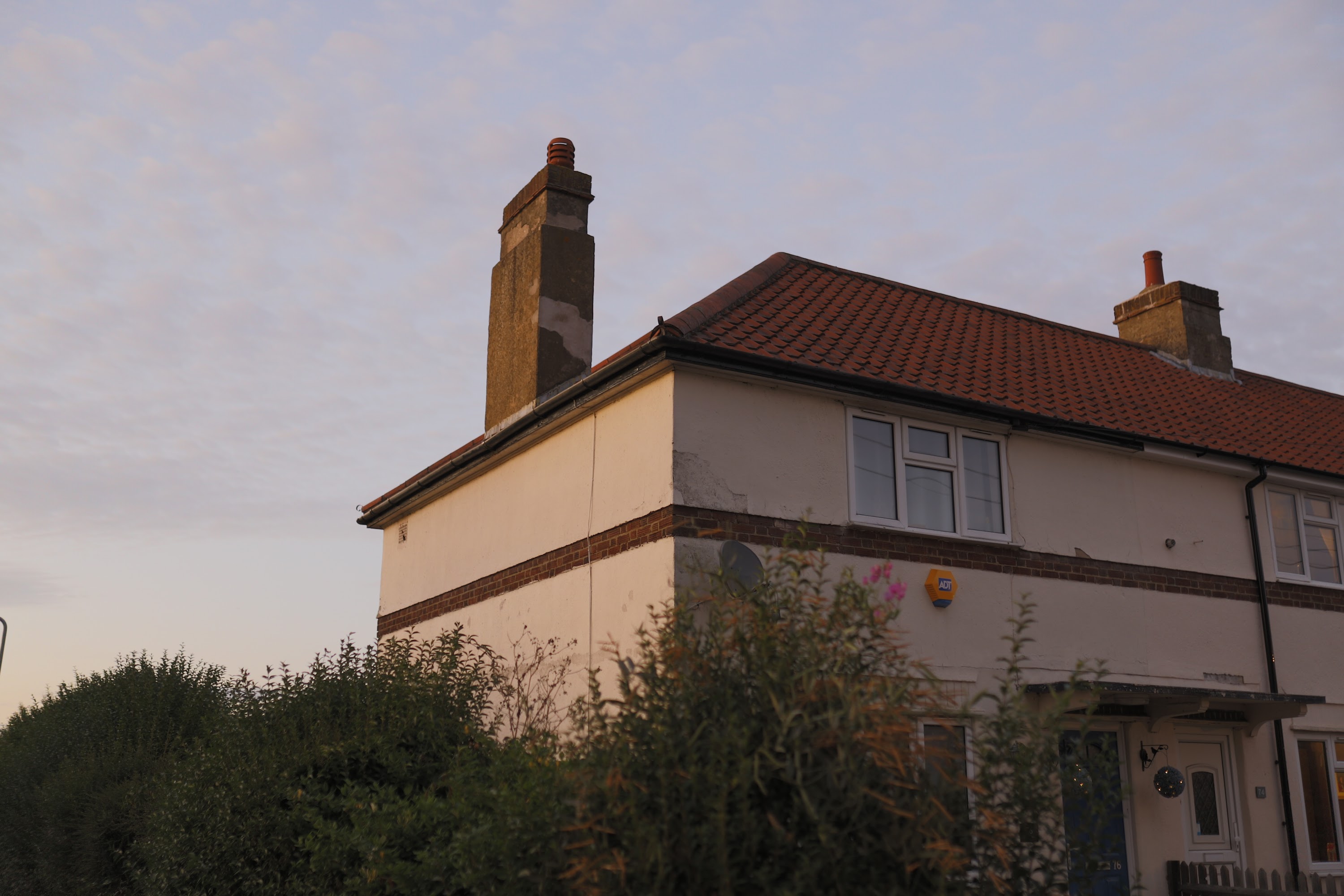 House with Red Tile Roof and Chimneys at Dusk