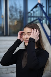 Urban Golden Hour Portrait — Young Woman in Black Against Glass Building