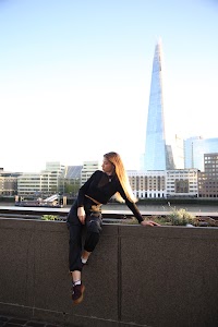 Urban Golden Hour Portrait — Young Woman in Black Against Glass Building