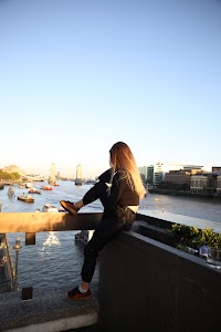 Urban Golden Hour Portrait — Young Woman in Black Against Glass Building