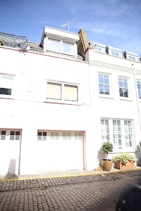 White Townhouse with Cobblestone Street and Potted Plants