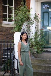 Woman in Olive Jumpsuit on Historic British Street