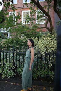 Woman in Olive Jumpsuit on Historic British Street