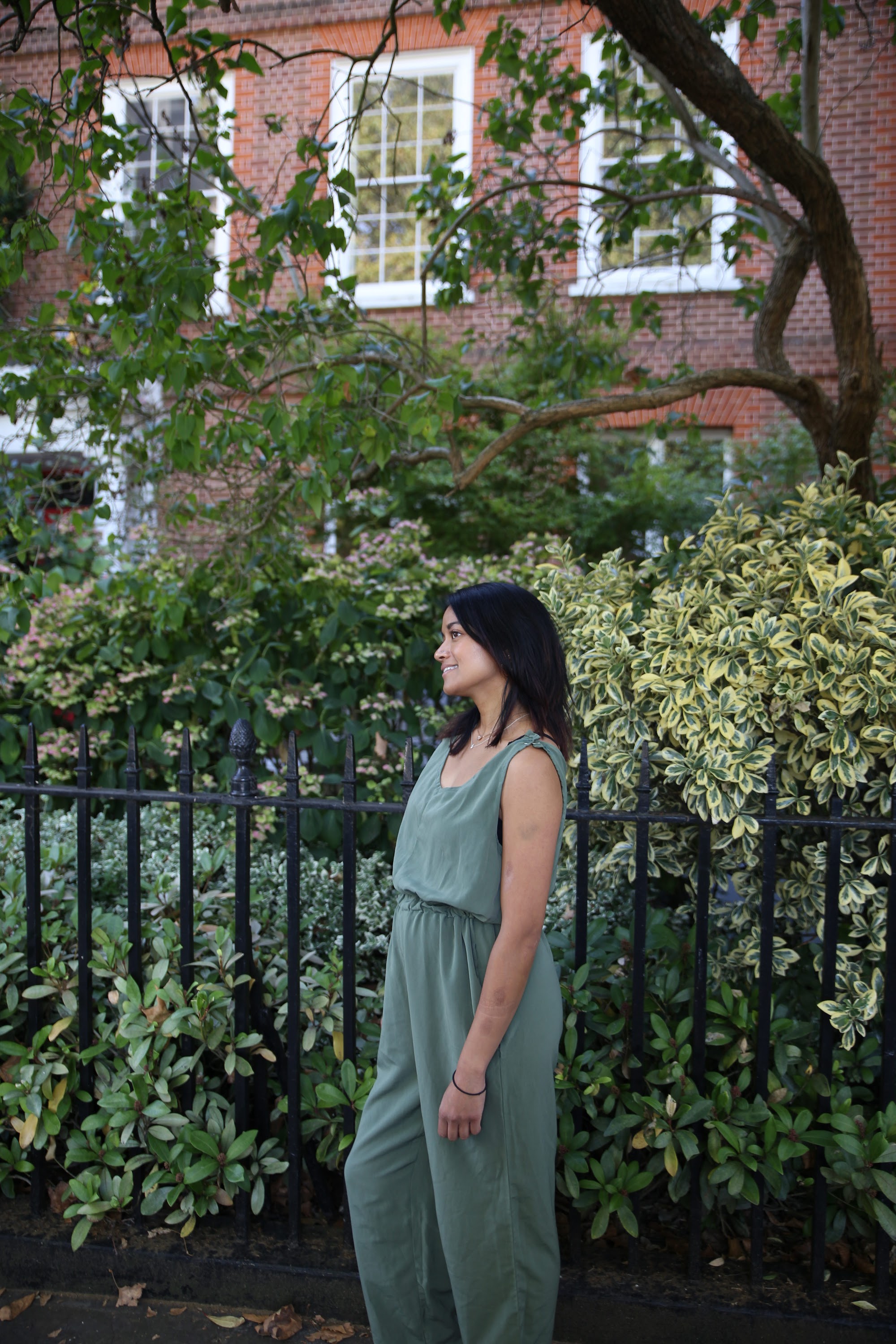 Woman in Olive Jumpsuit on Historic British Street