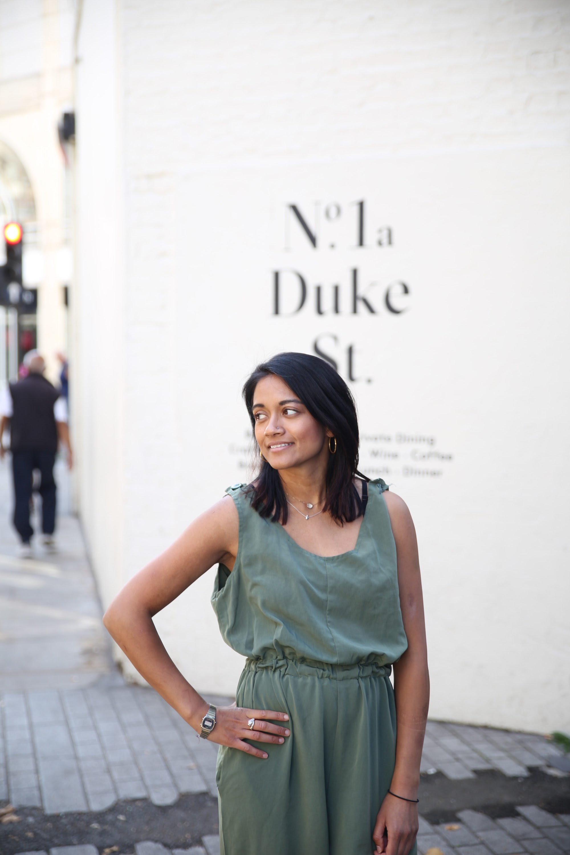 Woman in Olive Jumpsuit on Historic British Street
