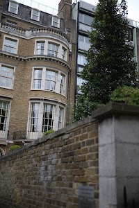 Victorian-style brick building with bay windows and modern adjacent structure