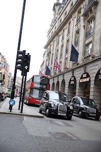 London Street Scene with Hitz Hotel, Double-Decker Bus, and Black Taxis