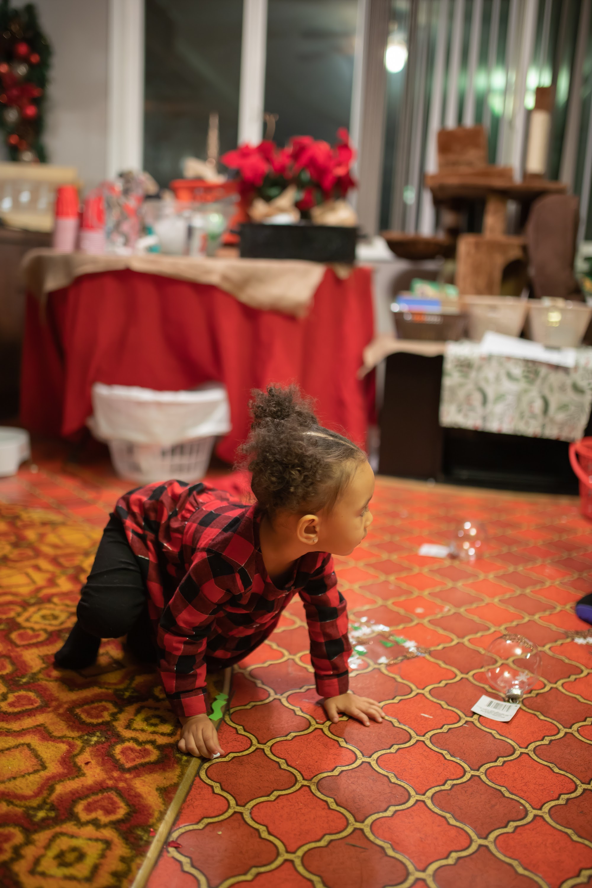 Child Crawling on Patterned Rug Near Christmas Decorations