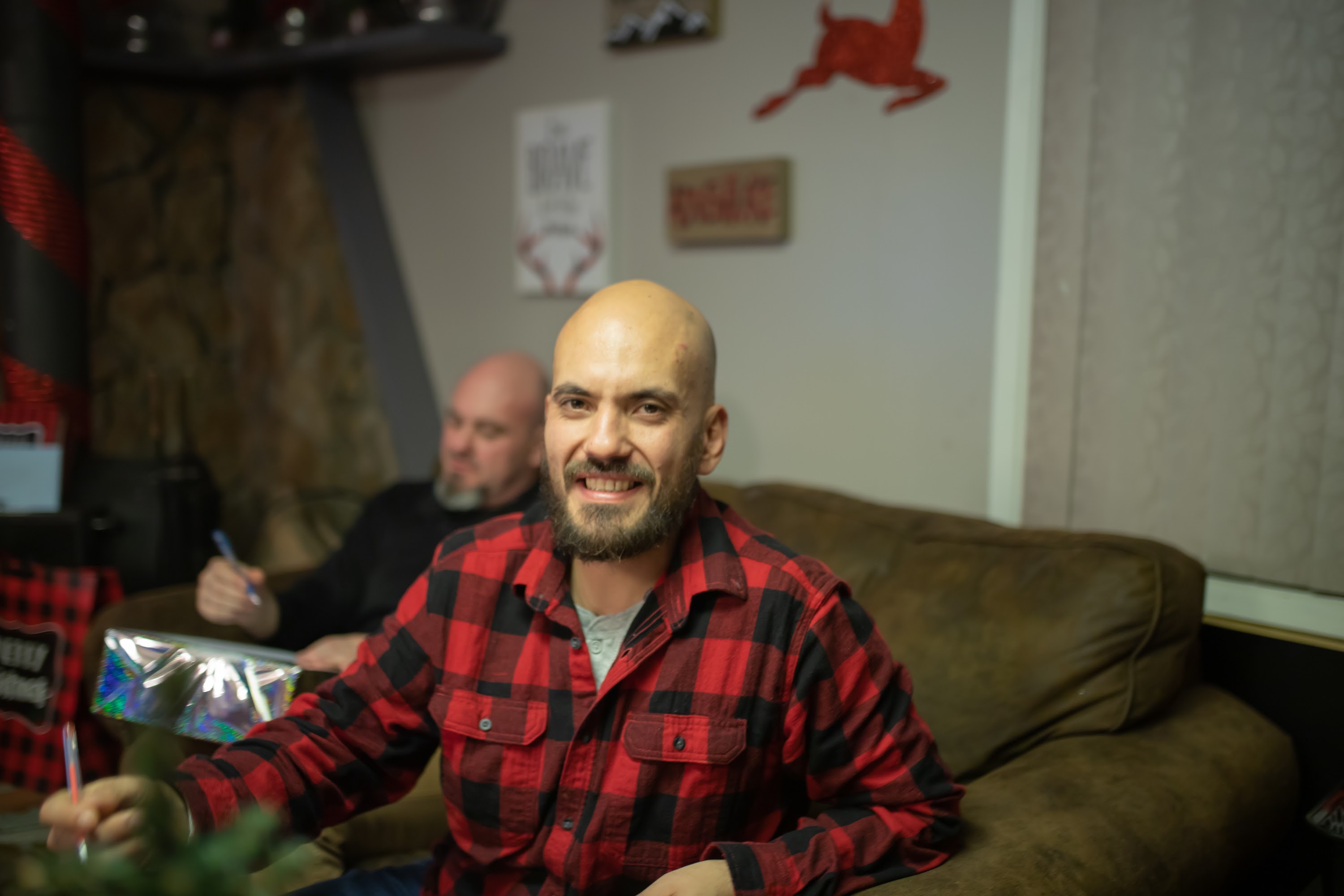 Bald Man in Red Plaid Shirt Smiling on Couch