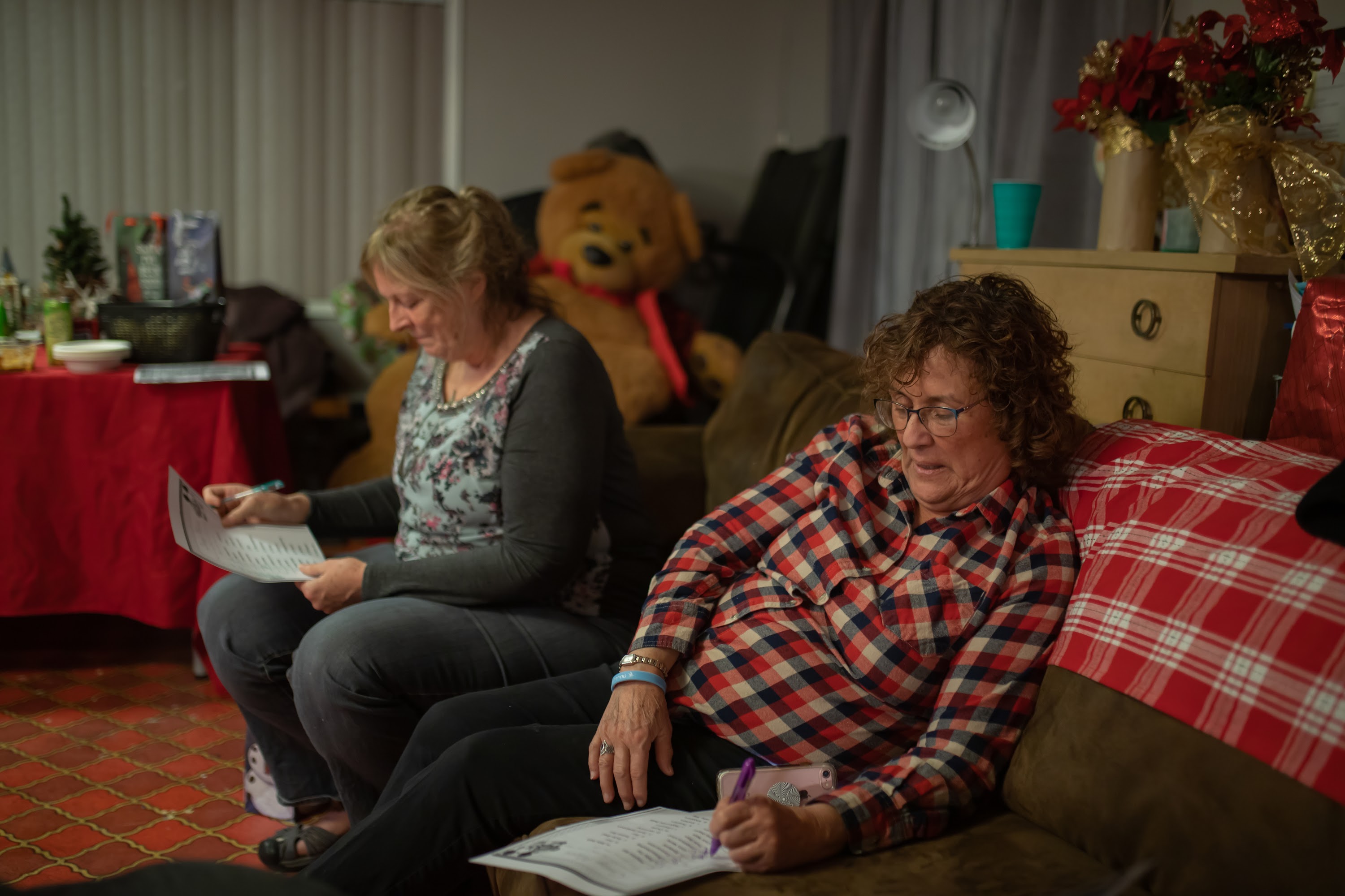 Two Women Focused on Papers in a Cozy Living Room