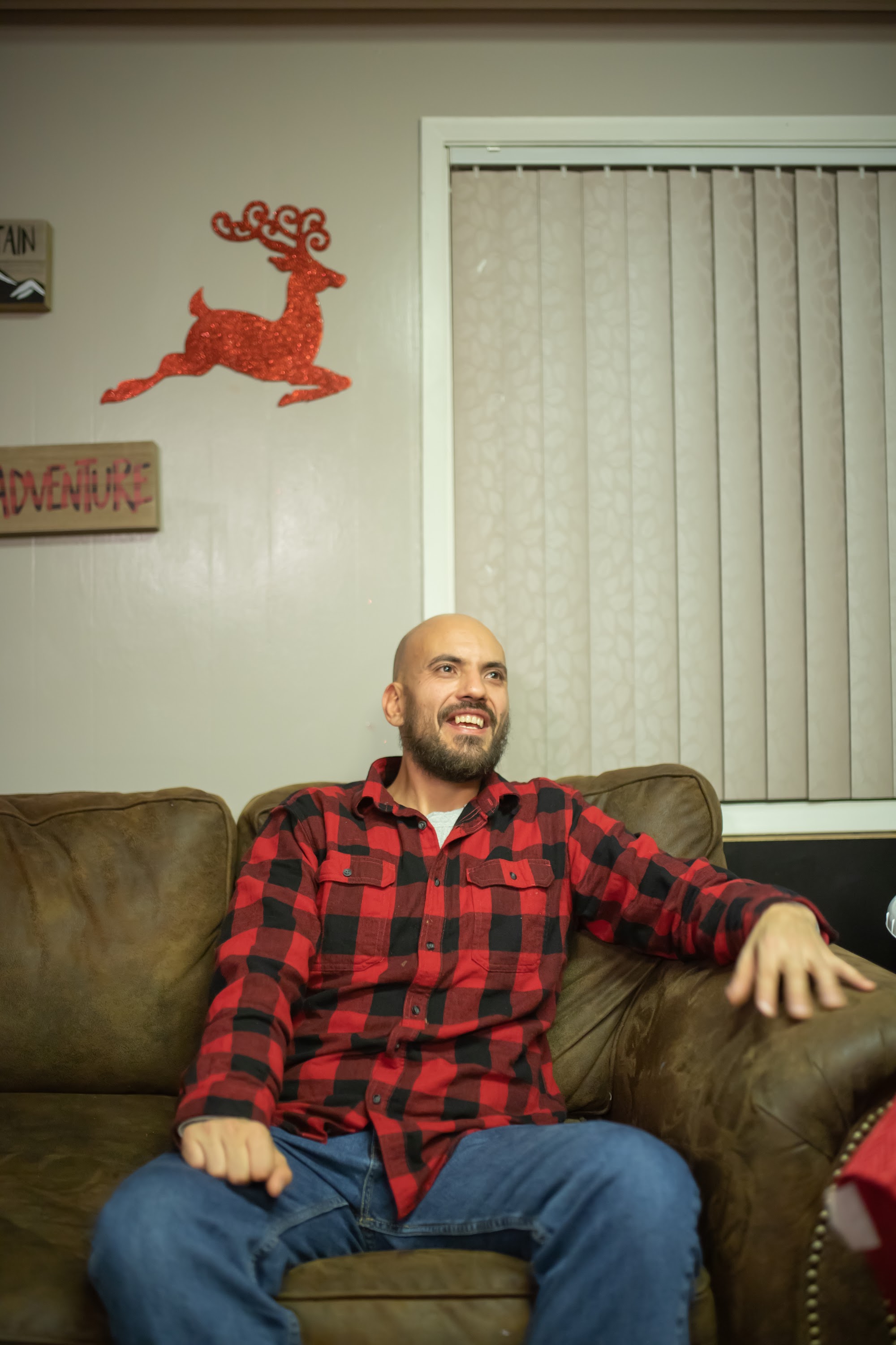 Bald Man in Red and Black Plaid Shirt Sitting on Leather Couch