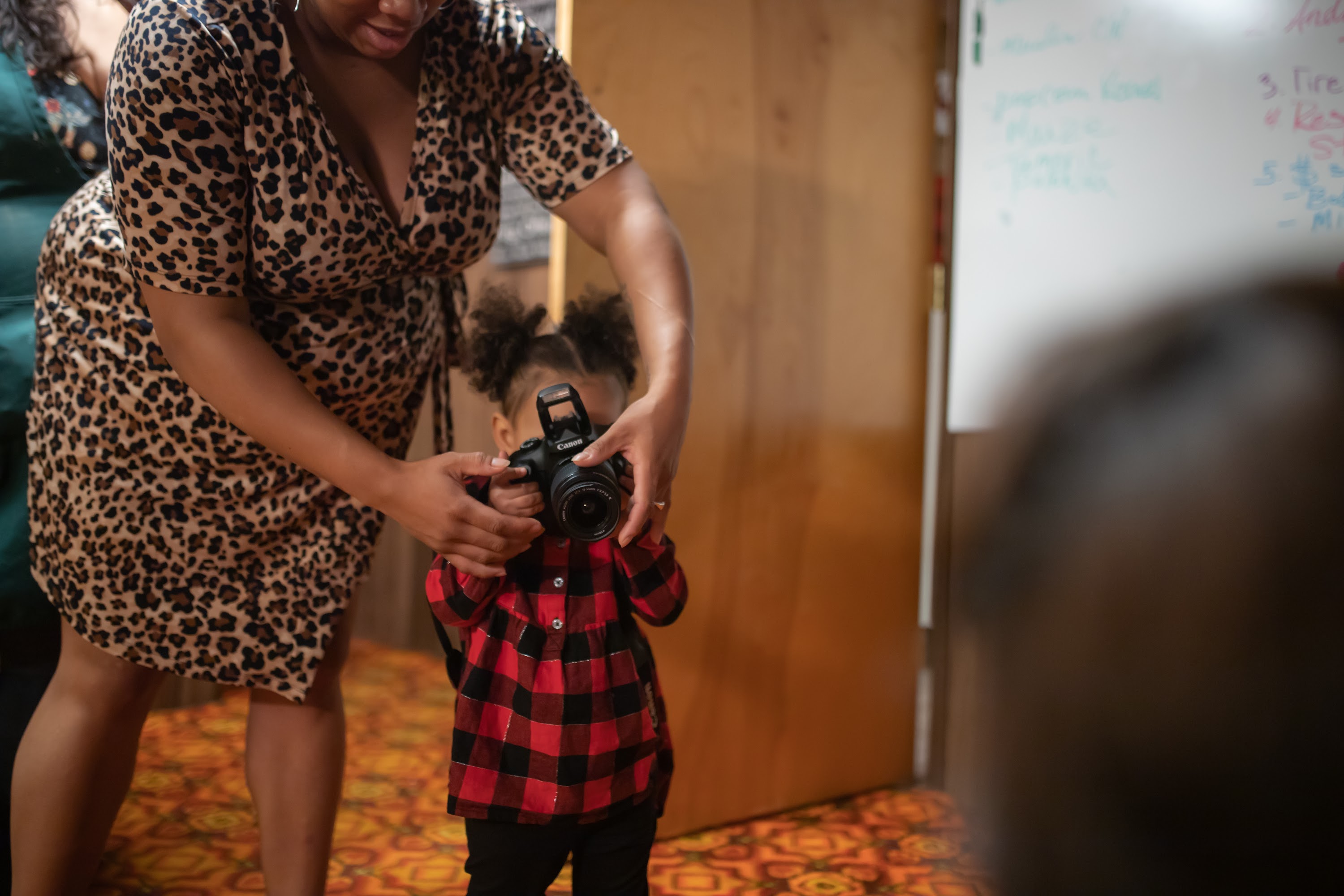Child Holding Camera with Adult Assistance