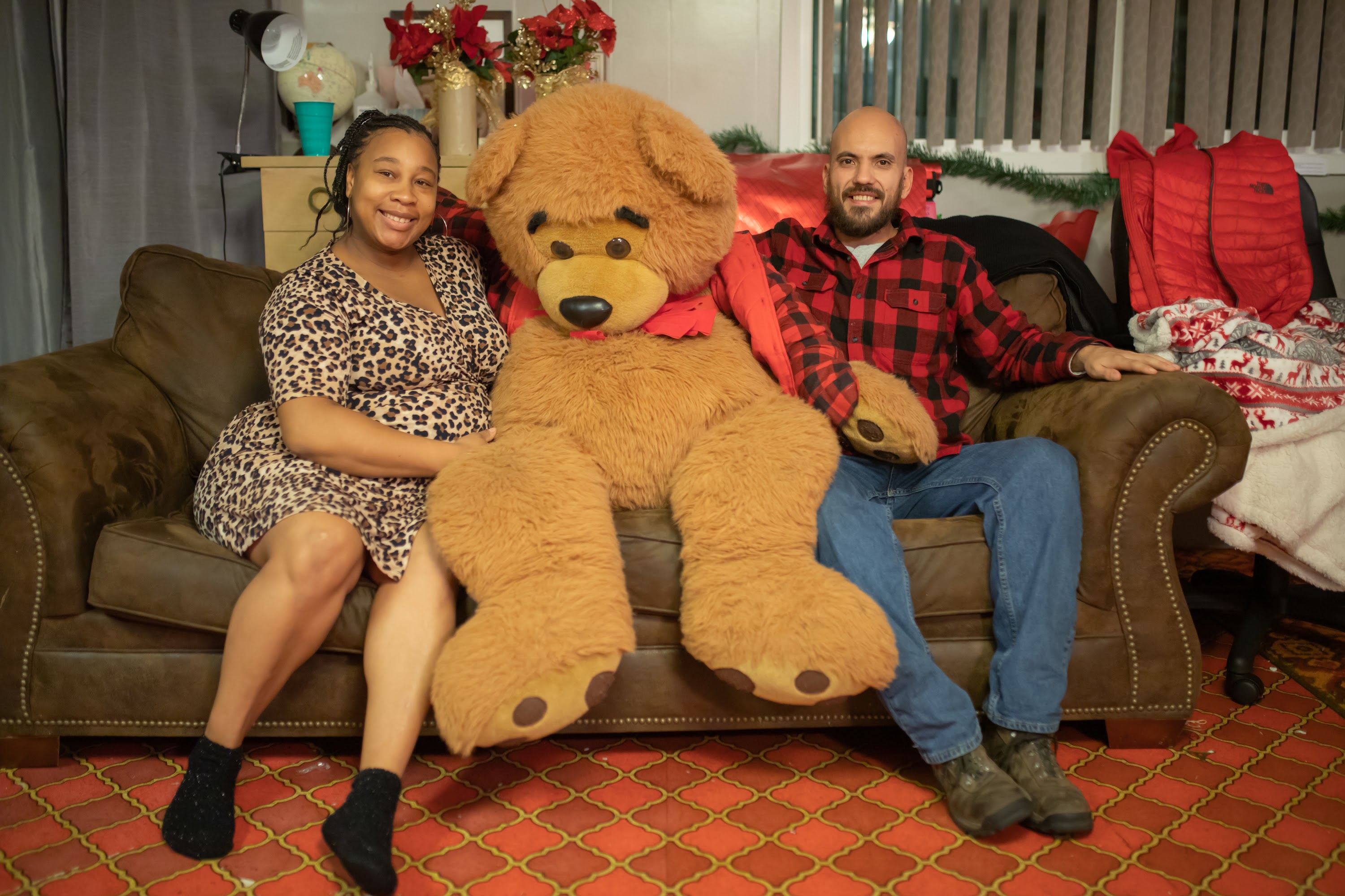 Couple Poses with Giant Teddy Bear on Couch