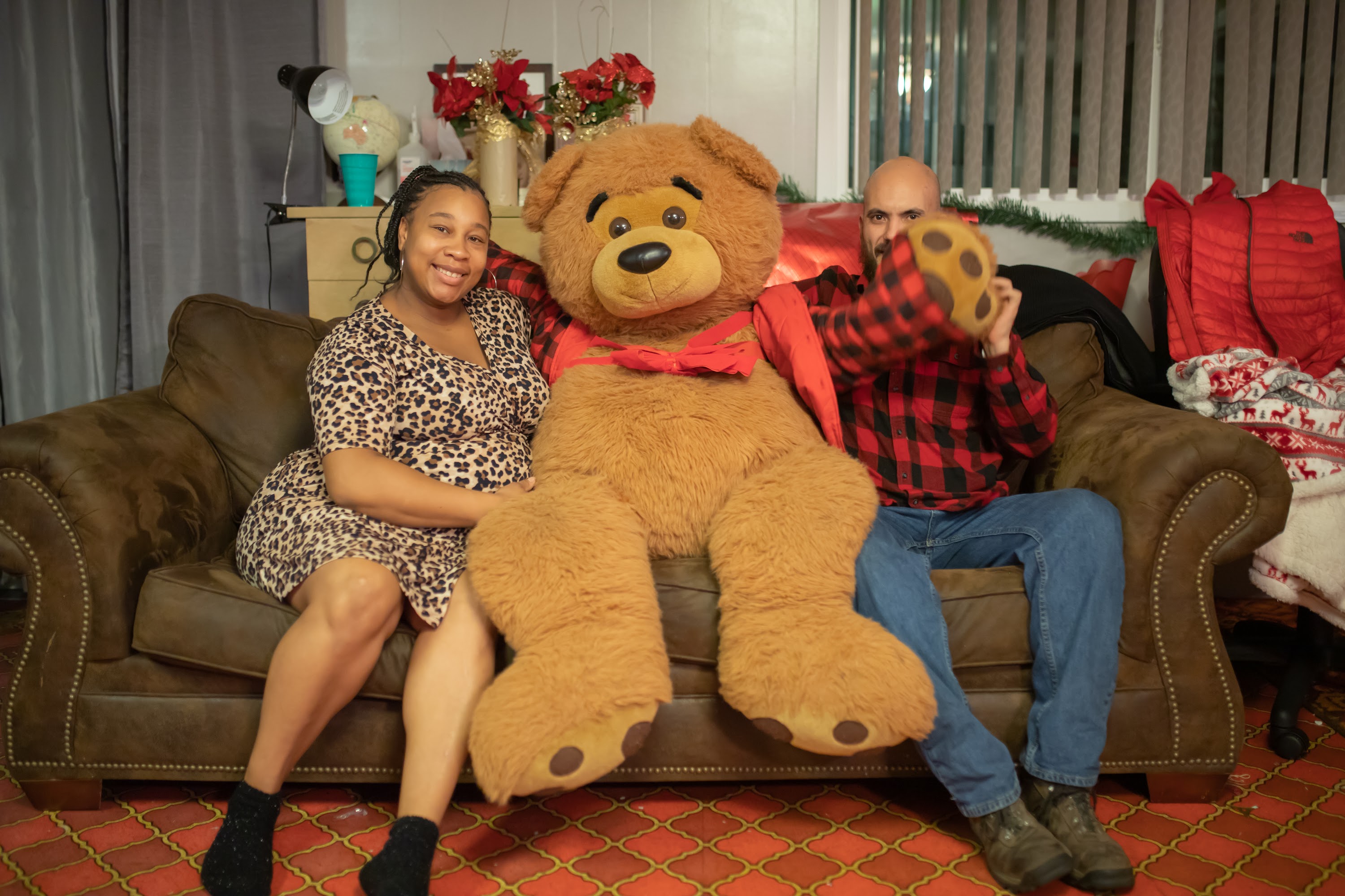 Couple Poses with Giant Teddy Bear on Couch