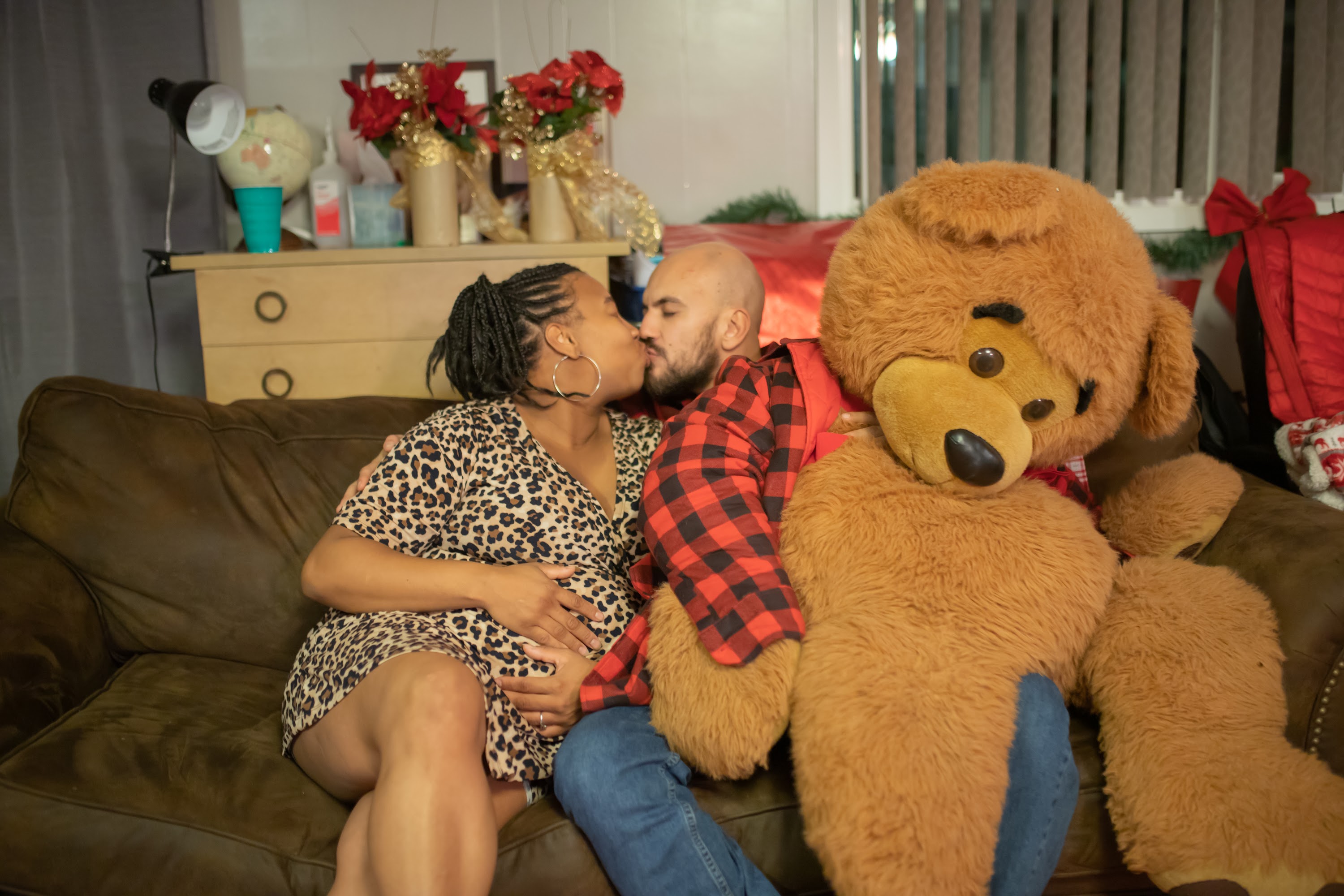 Couple Sharing a Kiss with a Giant Teddy Bear