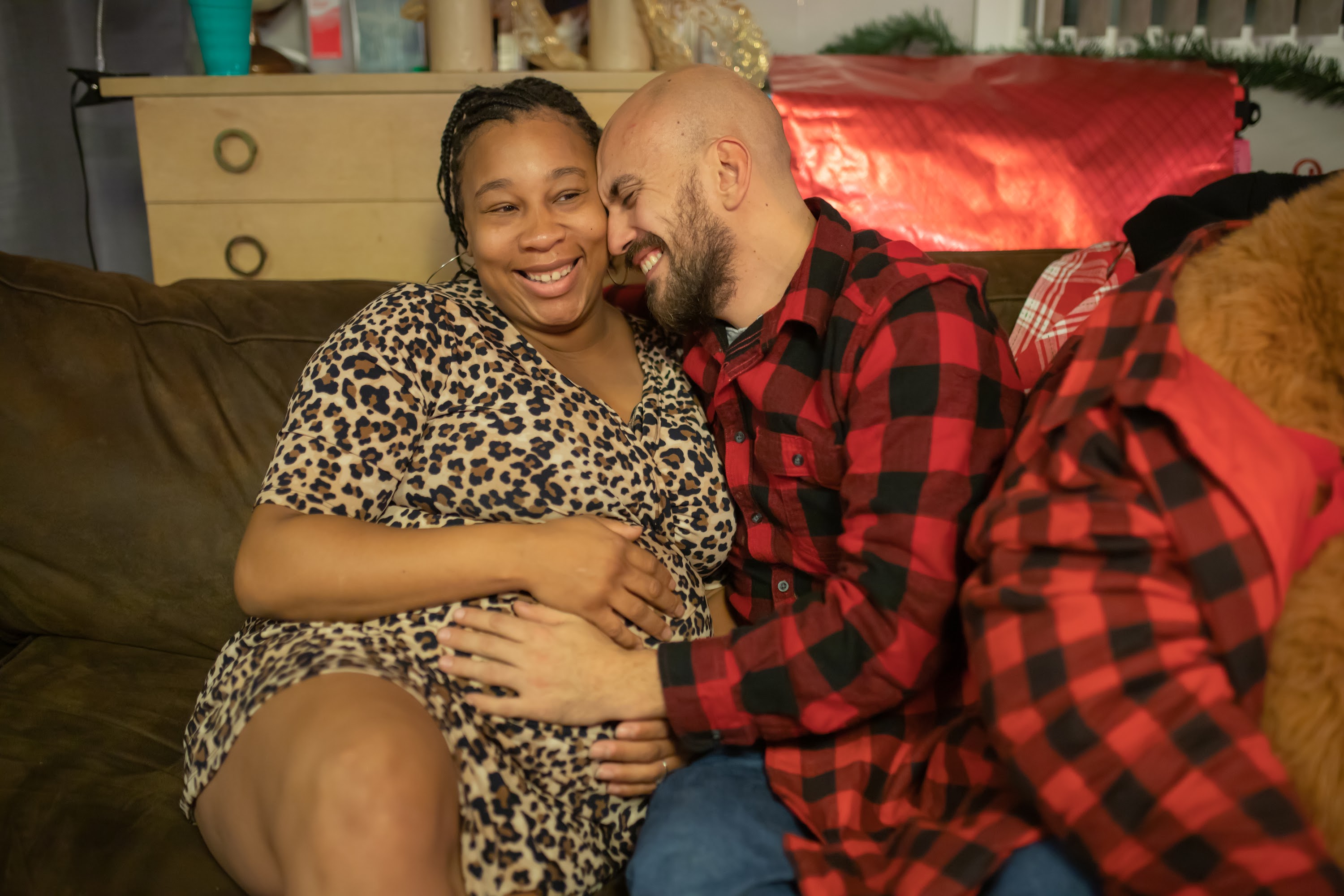 Pregnant Woman and Partner Sharing a Joyful Moment on the Couch