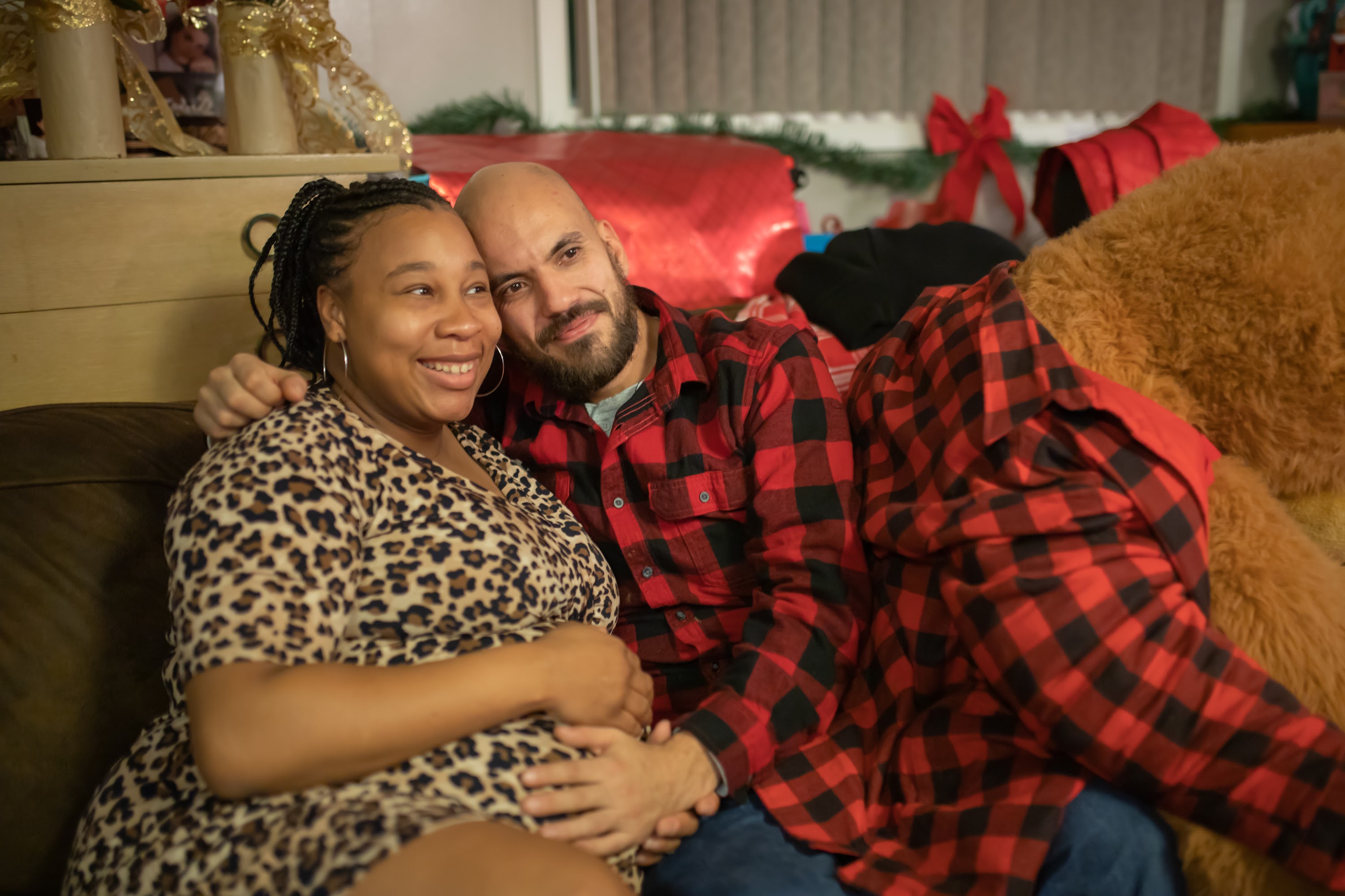 Pregnant Woman and Partner Relaxing on Couch During Holiday Season