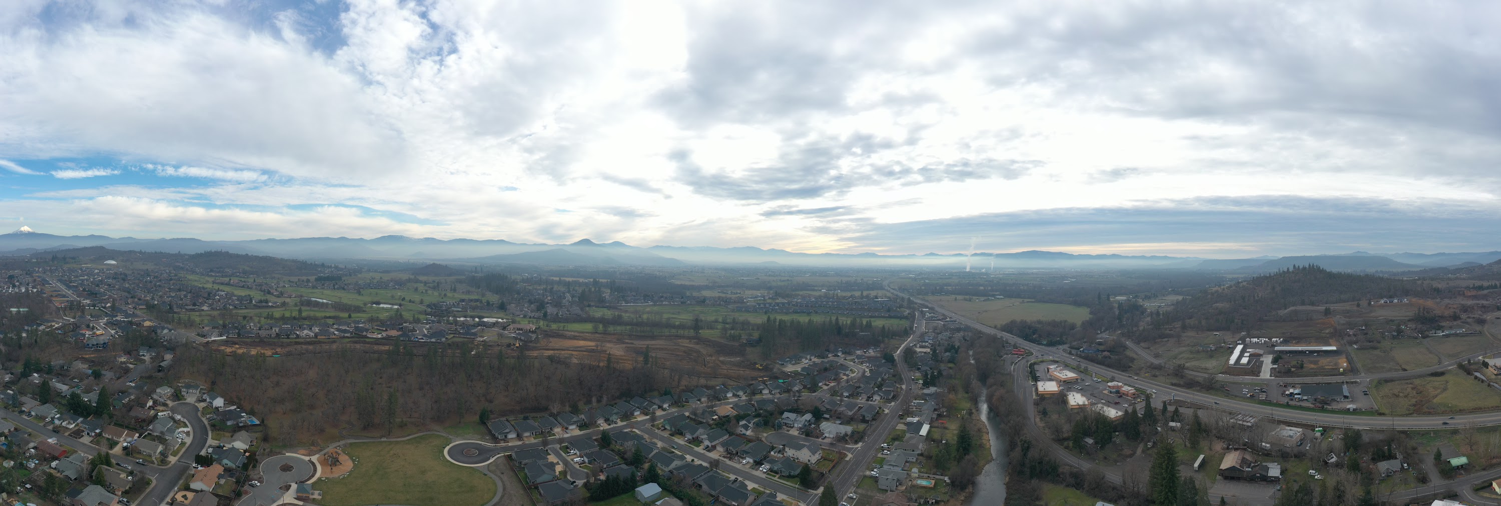 Panoramic Aerial View of Suburban Landscape with Distant Mountains