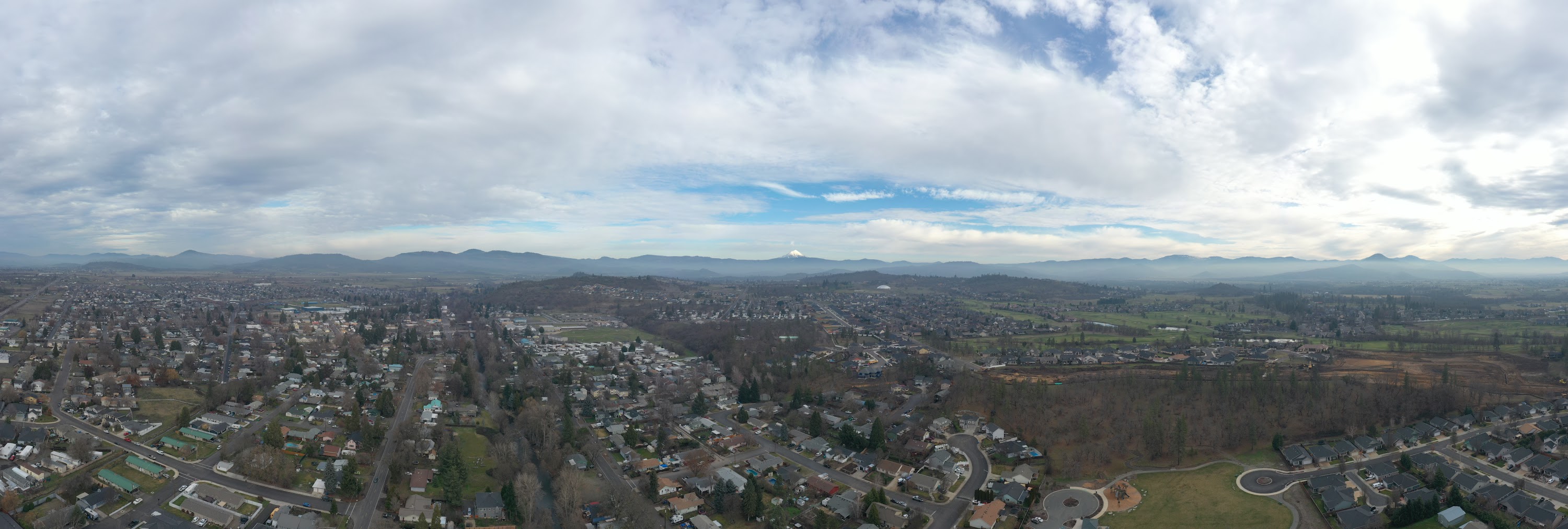Panoramic Aerial View of Suburban Town with Distant Mountain