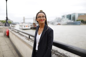 Smiling Woman in Pinstripe Blazer in European Cobblestone Alley