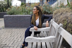 Smiling Woman in Pinstripe Blazer in European Cobblestone Alley
