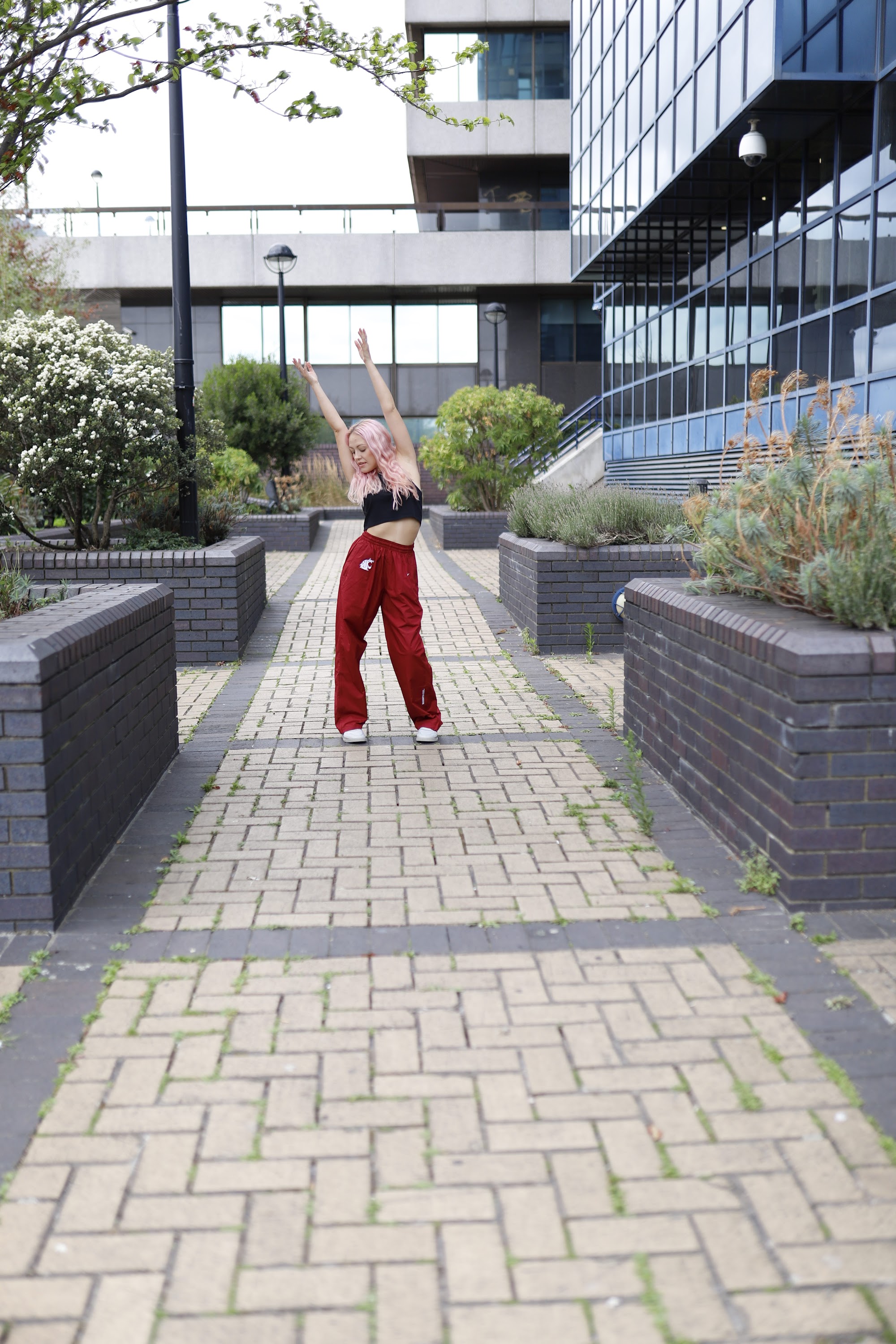 Young Woman with Pink Hair Posing on Urban Brick Plaza