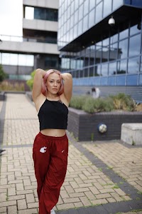 Young Woman with Pink Hair Posing on Urban Brick Plaza