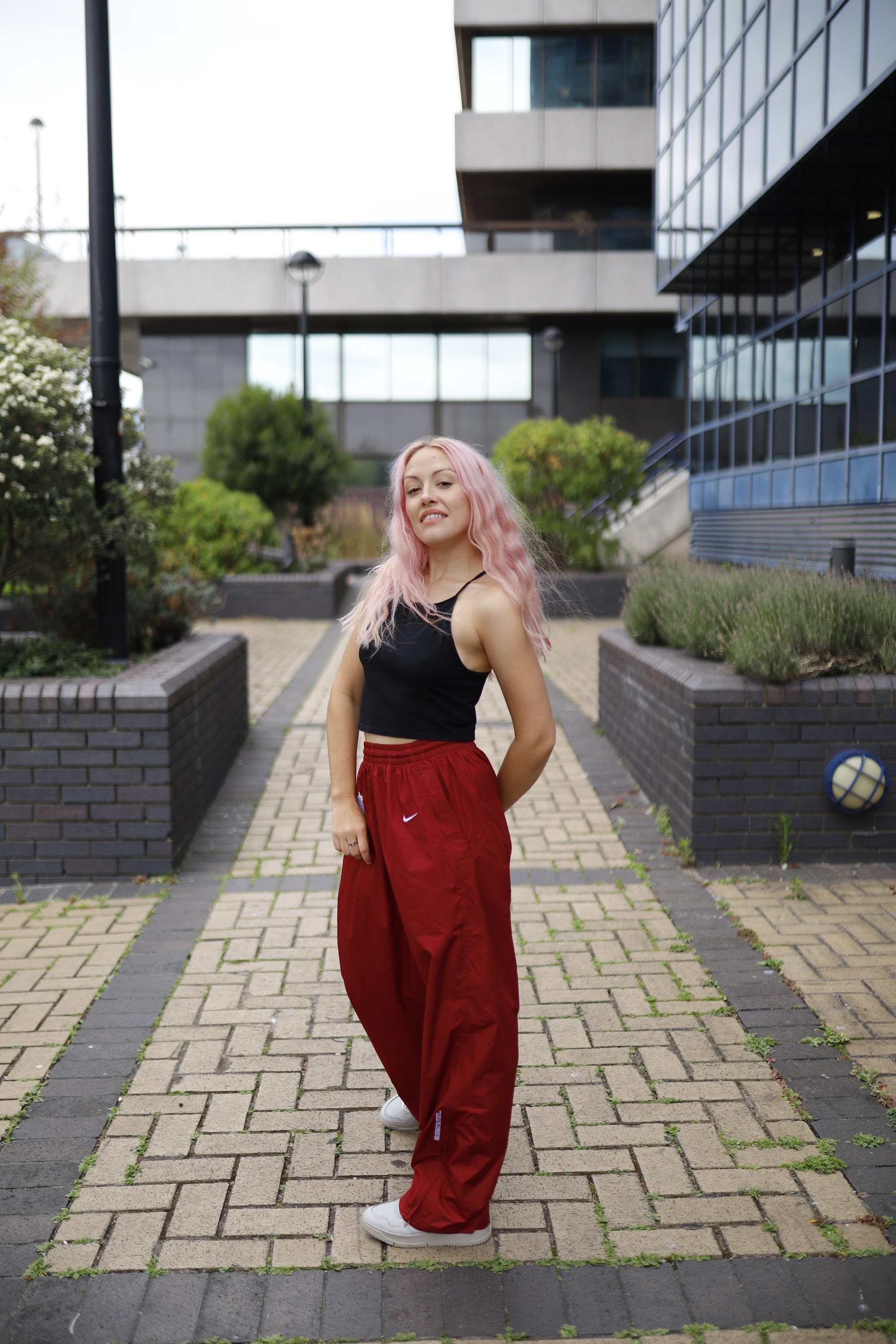Young Woman with Pink Hair Posing on Urban Brick Plaza