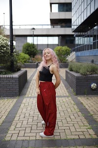 Young Woman with Pink Hair Posing on Urban Brick Plaza