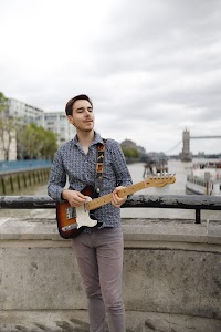 Guitarist Portrait on the Thames Embankment with Tower Bridge