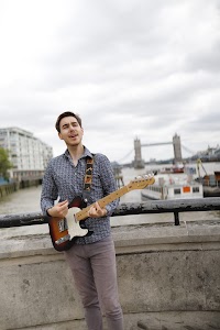 Guitarist Portrait on the Thames Embankment with Tower Bridge