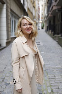 Blonde Woman in Beige Trench Coat on Cobblestone Alley