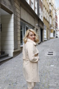 Blonde Woman in Beige Trench Coat on Cobblestone Alley
