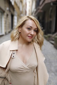 Blonde Woman in Beige Trench Coat on Cobblestone Alley