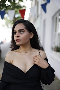 Woman in Off-Shoulder Black Dress on Urban Sidewalk