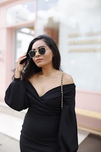 Woman in Off-Shoulder Black Dress on Urban Sidewalk