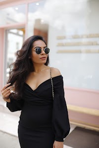 Woman in Off-Shoulder Black Dress on Urban Sidewalk