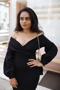 Woman in Off-Shoulder Black Dress on Urban Sidewalk